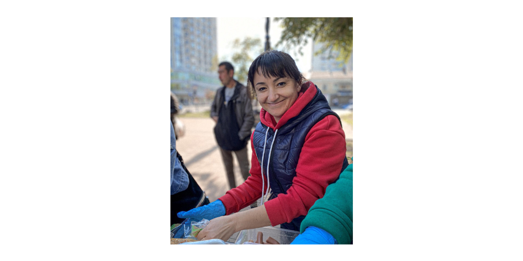 smiling volunteer handing out food