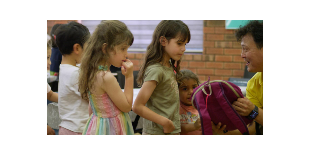 children picking up backpacks